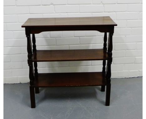 A mahogany three tier shelf unit on turned supports