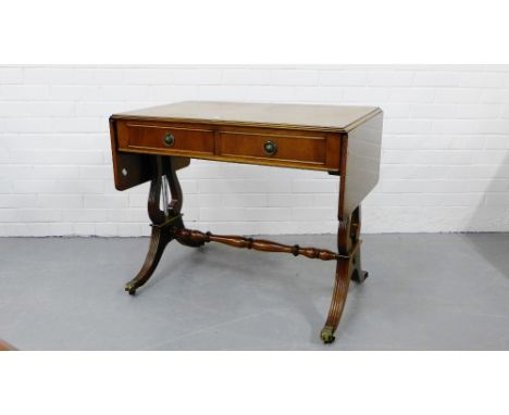 A mahogany and inlaid sofa table with twin drop flaps and two frieze drawers with turned stretcher and lyre side supports ter