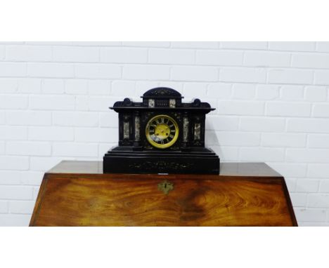 A Victorian black slate mantle clock with Roman numerals to the dial flanked by veined marble colonnades on a stepped rectang