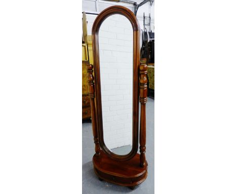 A mahogany framed cheval mirror with oval bevelled plate on shaped column supports, the base fitted a single frieze drawer on