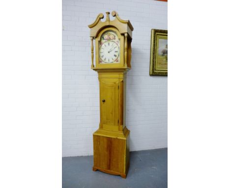 A pine long case clock with a broken swan neck pediment above a floral painted dial with Roman numerals, 220cm tall x 54cm wi