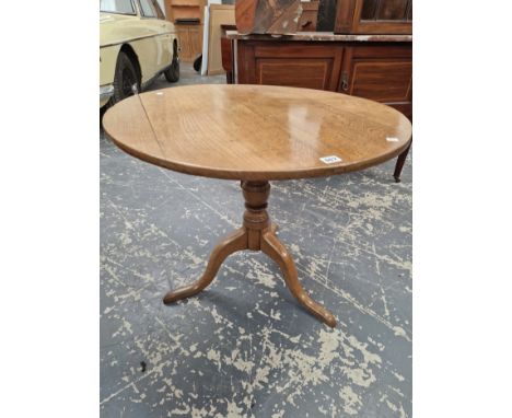AN ANTIQUE OAK CIRCULAR TILT TOP TABLE ON A BALUSTER COLUMN AND TRIPOD
