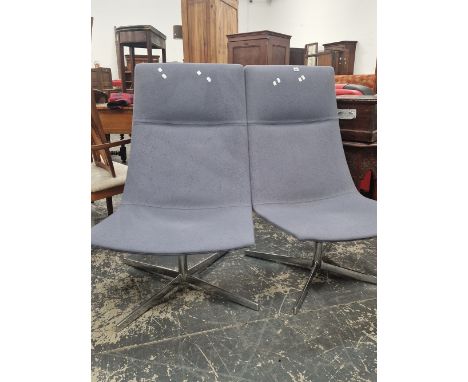 A PAIR OF JADE GREY UPHOLSTERED CHAIRS WITH THE RECTANGULAR BACKS RUNNING DOWN TO THE SEATS AND SWIVELLING ON ALUMINIUM COLUM