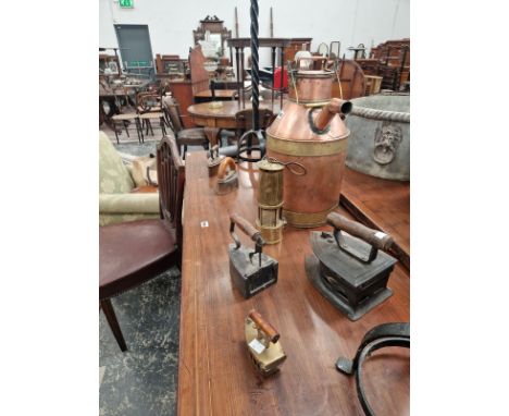 A PAIR OF SPIRALLY WROUGHT IRON FLOOR STANDING CANDLESTICKS, SIX CLOTHES IRONS, A MINERS LAMP AND A COPPER MILK CHURN