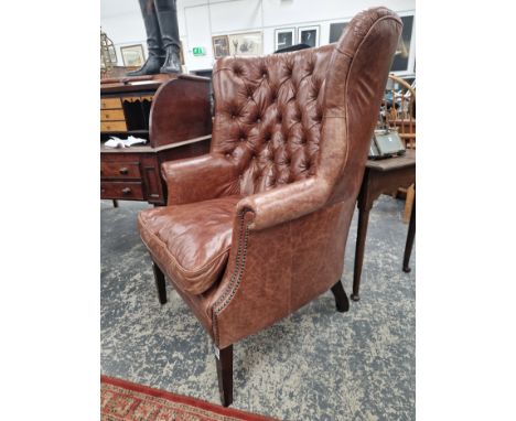 A MAHOGANY WING ARMCHAIR BUTTON UPHOLSTERED IN BROWN LEATHERETTE, CLOSE NAILING RUNNING FROM THE ARMS DOWN TO THE TAPERING SQ