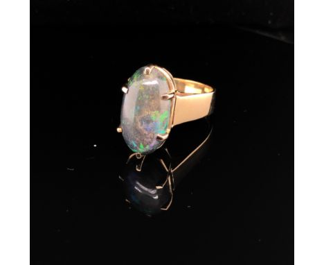 A 9ct HALLMARKED GOLD VINTAGE NATURAL OPAL SINGLE STONE RING. THE LARGE OVAL OPAL IN A RAISED SIX CLAW SETTING, MEASUREMENTS 