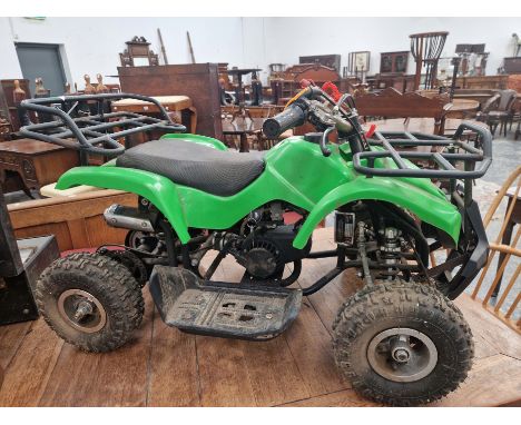 A CHILDS GREEN PLASTIC FOUR WHEELED VEHICLE WITH A LIVE ENGINE USING OIL AND PETROL MIXTURE FUEL