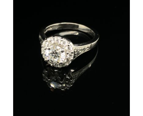 A GIA ROUND BRILLIANT CUT DIAMOND AND PLATINUM RING. THE CENTRE DIAMOND 0.71cts, SURROUNDED BY A HALO OF 12 FURTHER ROUND BRI