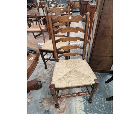 A SET OF SIX OAK LADDER BACK CHAIRS WITH RUSH DROP IN SEATS