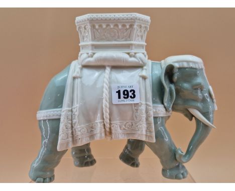 A ROYAL WORCESTER GLAZED PARIAN CELADON COLOURED ELEPHANT CAPARISSONED WITH A WHITE HOWDAH.   H 21cms.
