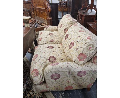 A TWO SEAT SOFA WITH BRASS CASTER FEET AND UPHOLSTERED IN SUSANI STYLE PRINTED MATERIAL.&nbsp;H 83 W 183 D 106&nbsp;