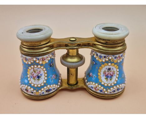 A LEATHER CASED PAIR OF OPERA GLASSES WITH JEWELLED AND FLOWER PAINTED BLUE GROUND ENAMEL BARRELS AND MOTHER OF PEARL FRAMED 