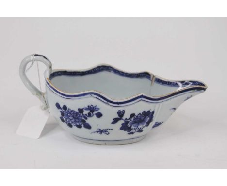 A 18th century Chinese blue and white porcelain saueboat, having a wavy rim and scroll handle (a/f)