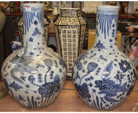 A pair of large Chinese blue and white pottery bottle vases, decorated with fish and flowers, h.58cm 