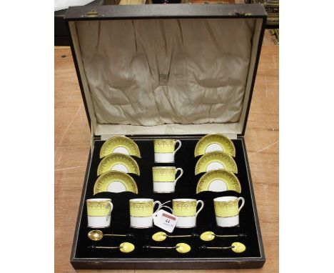 A set of six Cauldon coffee cans and saucers with gilt anthemion decoration, cased with a set of six gilt metal and enamel co