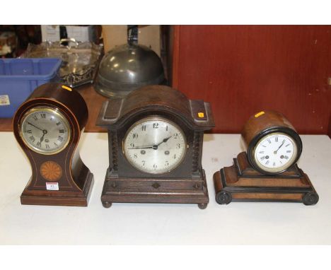 An Edwardian mahogany and inlaid balloon shaped mantel clock, the brushed steel dial showing Roman numeral markers, signed J.