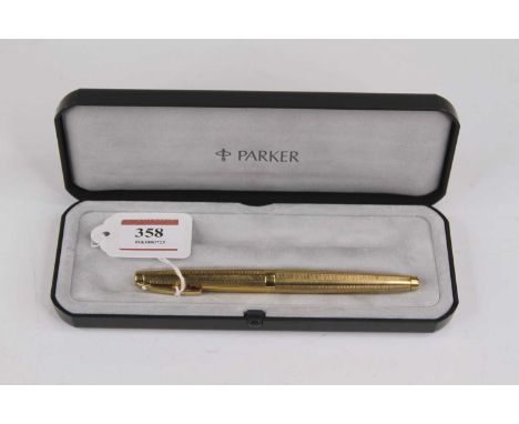 A Sheaffer fountain pen having a 14 carat gold nib with engine turned yellow metal cap and barrel, in associated Parker case