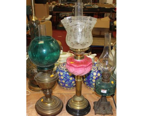 A Victorian oil lamp having a translucent blue glass reservoir on a cast iron base, height excluding chimney 29cm, together w