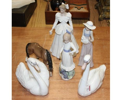 A Lladro porcelain figure of a swan shown seated with wings raised, h. 17cm, together with another Lladro figure of a swan, t