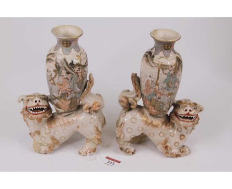A pair of Chinese pottery vases, each mounted upon a pottery dog of Fo, h.22cm