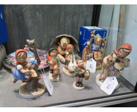 Six Hummel figures, including 'Umbrella Boy', 'Merry Wanderer (Oberammergau 2000), a Hummel Goebel 'Umbrella Boy' box, a Humm