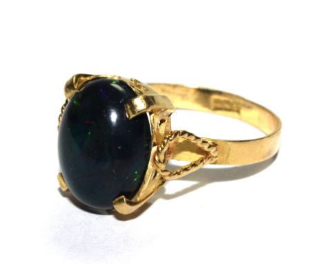 A continental gold ring set with cabochon black opal 