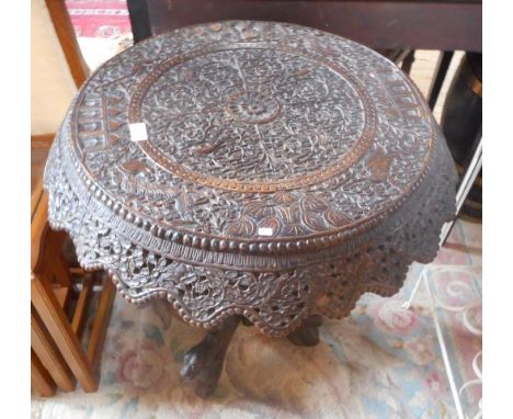 An Anglo-Indian circular table, carved decoration with pierced frieze over central column with tripod base, having carved lio