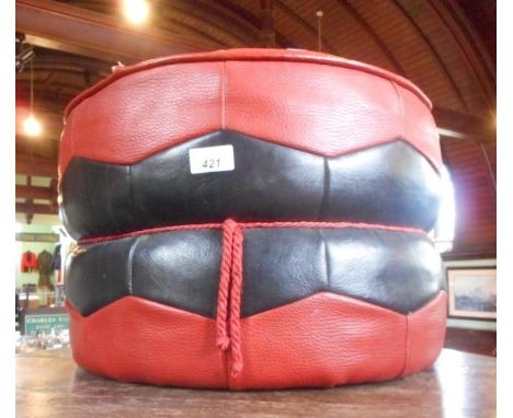 An Eastern-style leather pouffe, with geometric pattern on red ground, maker H. C. Hanley, Worcester Limited.
