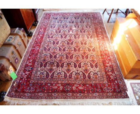 A hand made Iranian woollen Malayer carpet, the central panel decorated with Paisley-style motifs, with similar decoration on