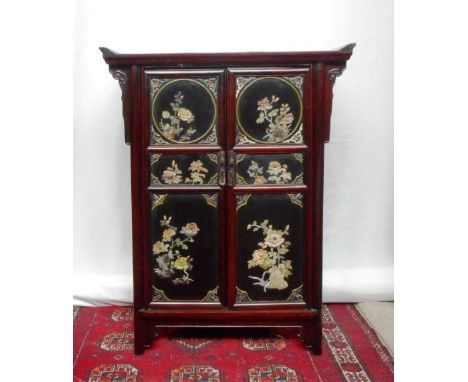 A reproduction Chinese two door cabinet, the interior with three fitted drawers and a shelf, the outer panels decorated in re