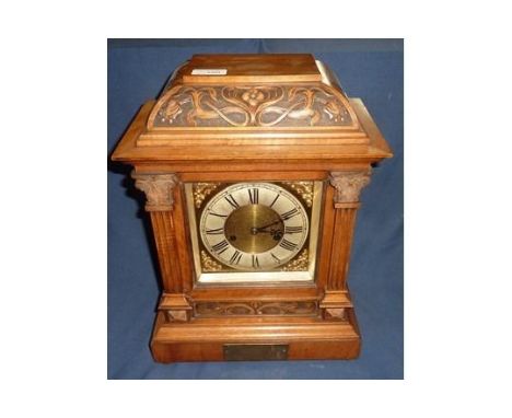 Carved walnut cased mantel clock, brass and steel face with brass presentation plaque, with striking movement stamped with cr