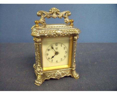 Silver plated repeating carriage type clock with ornate case, with floral detail and white enamel dial, the movement marked W