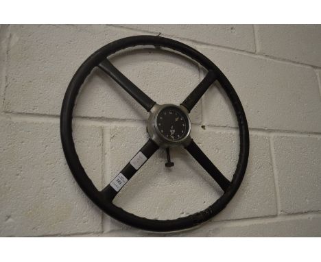 A novelty steering wheel with a Smiths clock at the centre (af).