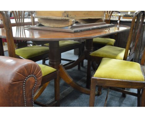 A Georgian style mahogany twin pillar extending dining table with one leaf.