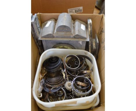 An old mantel clock and various clock parts.