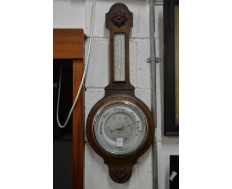 An oak cased aneroid barometer and thermometer.