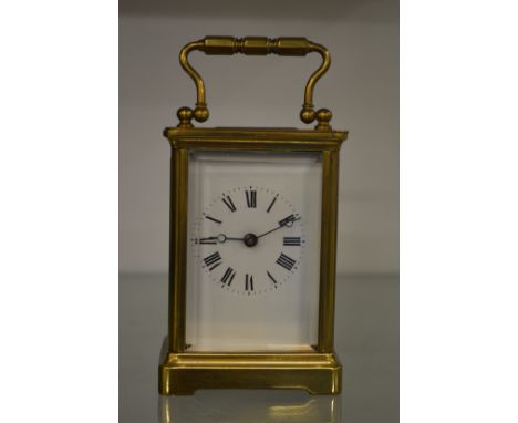 A brass carriage clock with replacement escapement (original escapement included).