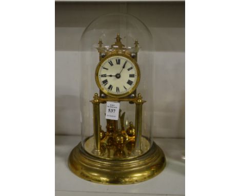 A brass anniversary clock with glass dome.