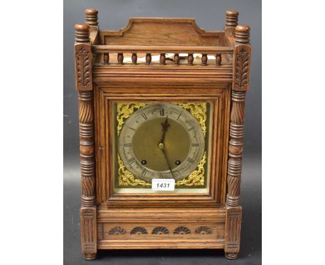 A late Victorian oak mantel clock, galleried pediment, turned supports, twin winding holes, silvered chapter ring, Roman Nume