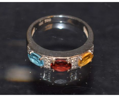 A diamond, citrine, garnet and topaz multi stone dress ring, central oval garnet flanked to either side by a conforming citri