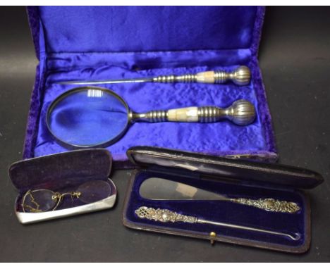 A pair of Victorian silver handled button hook and shoe horns, Birmingham 1900, cased; a magnifying glass and paper knife; et