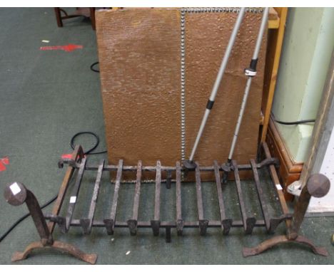 A three piece cast iron fire grate with a hammered copper fire back
