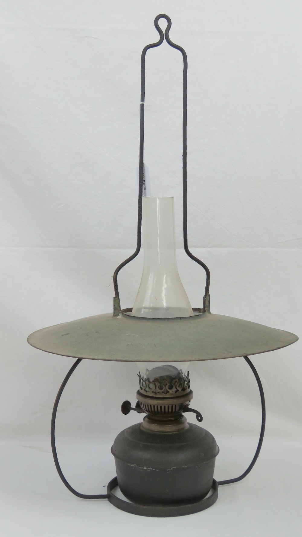A vintage hanging oil lamp complete with shade and chimney.