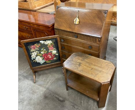 An early 20th Century carved oak bureau, an Art Deco oak occasional table and an embroidered firescreen/table