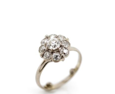 Old cut diamond and white gold daisy ring set with nine old European cut diamonds set in a white gold shank. Unmarked. Approx