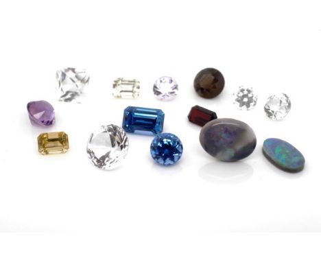 A group of loose coloured gemstones include amethyst, garnet, tourmaline, white topaz, blue topaz, citrines, solid and backed