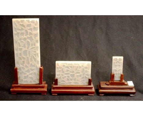 Three vintage Chinese carved jade panels all with similar decorated floral vine carving, of different sizes, on carved timber
