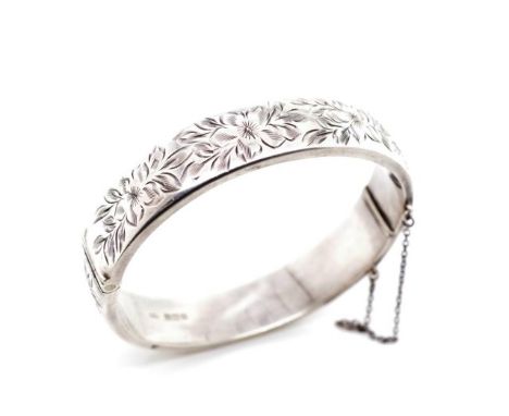 Elizabeth II sterling silver bangle with engraved floral work panels, box clasp, safety chain and swivel hinge. Marked Birmin