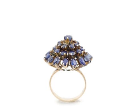 Sapphire set rose gold ring set with oval and round cut blue sapphires in a four tiered setting. Marked 18k. Approx weight 5.