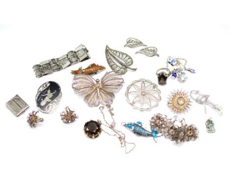 A group silver and white metal jewellery includes enamel articulating fish, filigree brooches, ear clips, bracelets, a marked